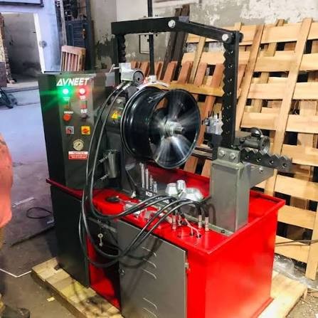 Workshop machine straightening an alloy wheel